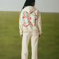 OFF-WHITE SWEATPANTS WITH GREEN EMBROIDERY