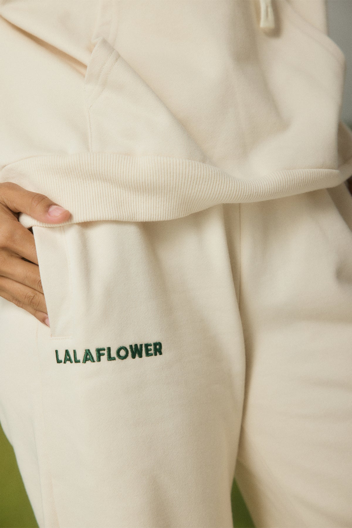 OFF-WHITE SWEATPANTS WITH GREEN EMBROIDERY