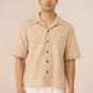 Man wearing a beige checkered shirt with short sleeves on a beige background Calling June