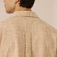Man wearing a beige patterned shirt against a neutral background Calling June