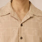 Close-up of a beige patterned shirt worn by a person Calling June