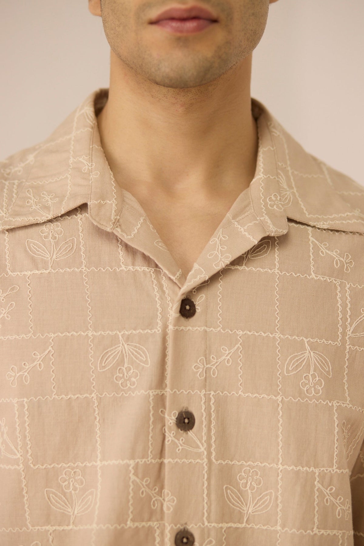 Close-up of a beige patterned shirt worn by a person Calling June