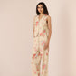 Woman wearing a floral jumpsuit on a plain background Calling June