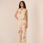 Woman wearing a floral jumpsuit on a plain background Calling June
