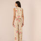 Woman wearing a floral sleeveless top and pants on a beige background Calling June