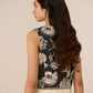 Woman wearing a sleeveless top with a floral pattern on a beige background Calling June