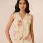 Woman wearing a floral sleeveless top and pants against a plain background Calling June