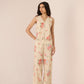 Woman wearing a floral jumpsuit on a plain background Calling June