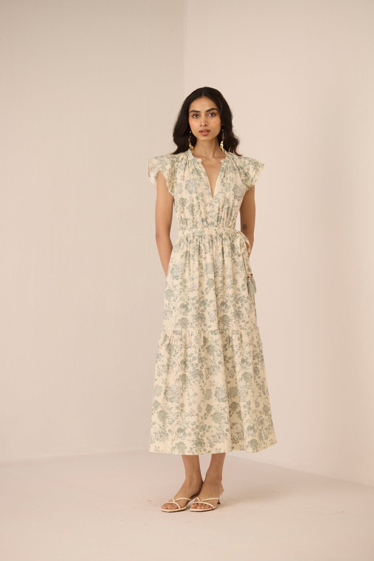 Woman wearing a floral dress against a plain background Calling June