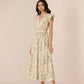 Woman wearing a floral dress against a plain background Calling June