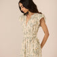 Woman wearing a floral dress against a plain background Calling June