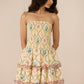 Woman wearing a floral strapless dress against a beige background Calling June