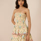 Woman wearing a strapless floral dress against a beige background Calling June