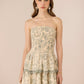 Woman wearing a strapless floral dress against a beige background Calling June