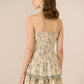 Woman wearing a floral strapless dress against a beige background Calling June