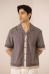 Man wearing a patterned shirt with a beige background Calling June