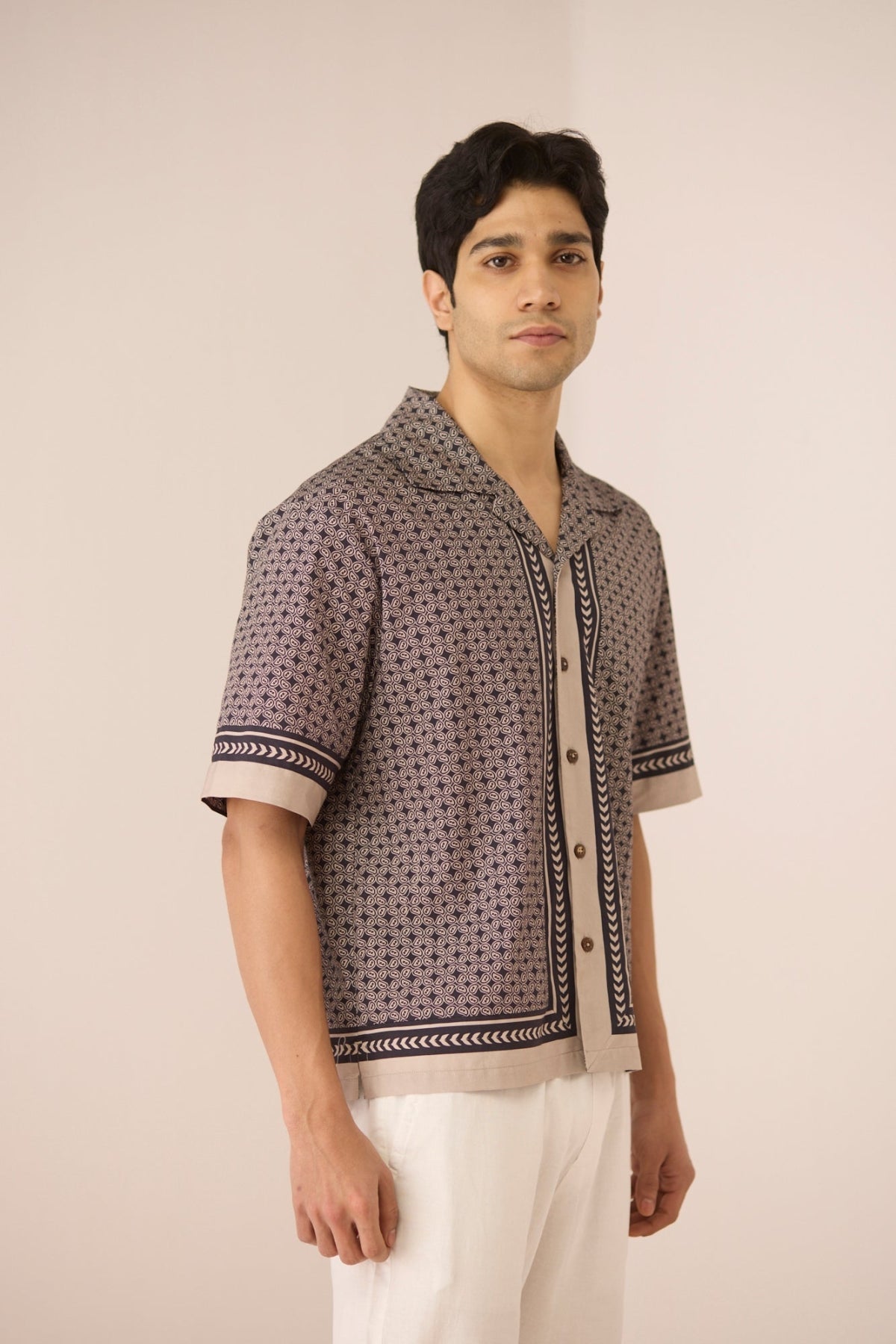 Man wearing a patterned shirt with a plain background Calling June