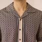 Man wearing a patterned shirt with a neutral background Calling June