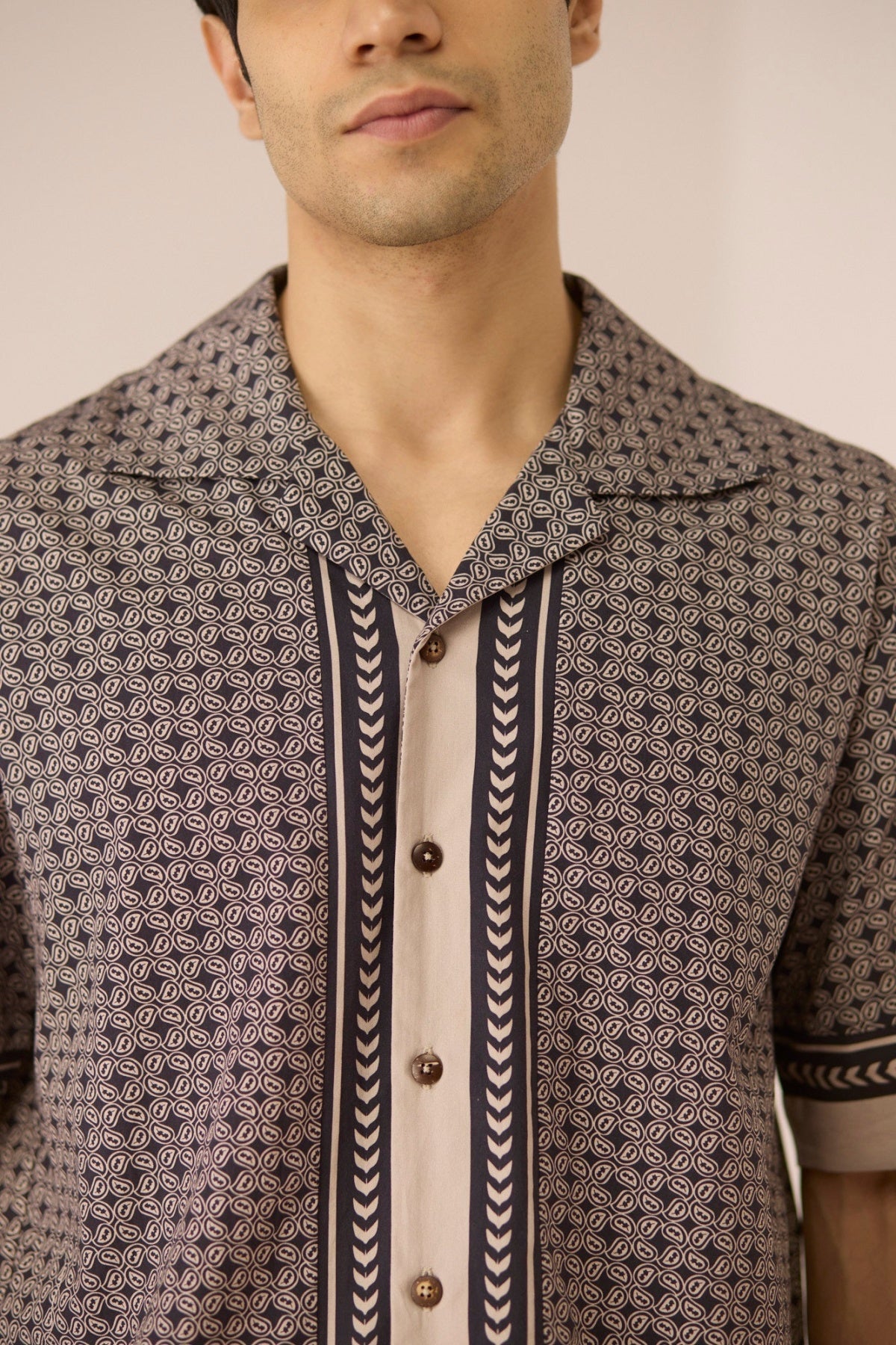 Man wearing a patterned shirt with a neutral background Calling June