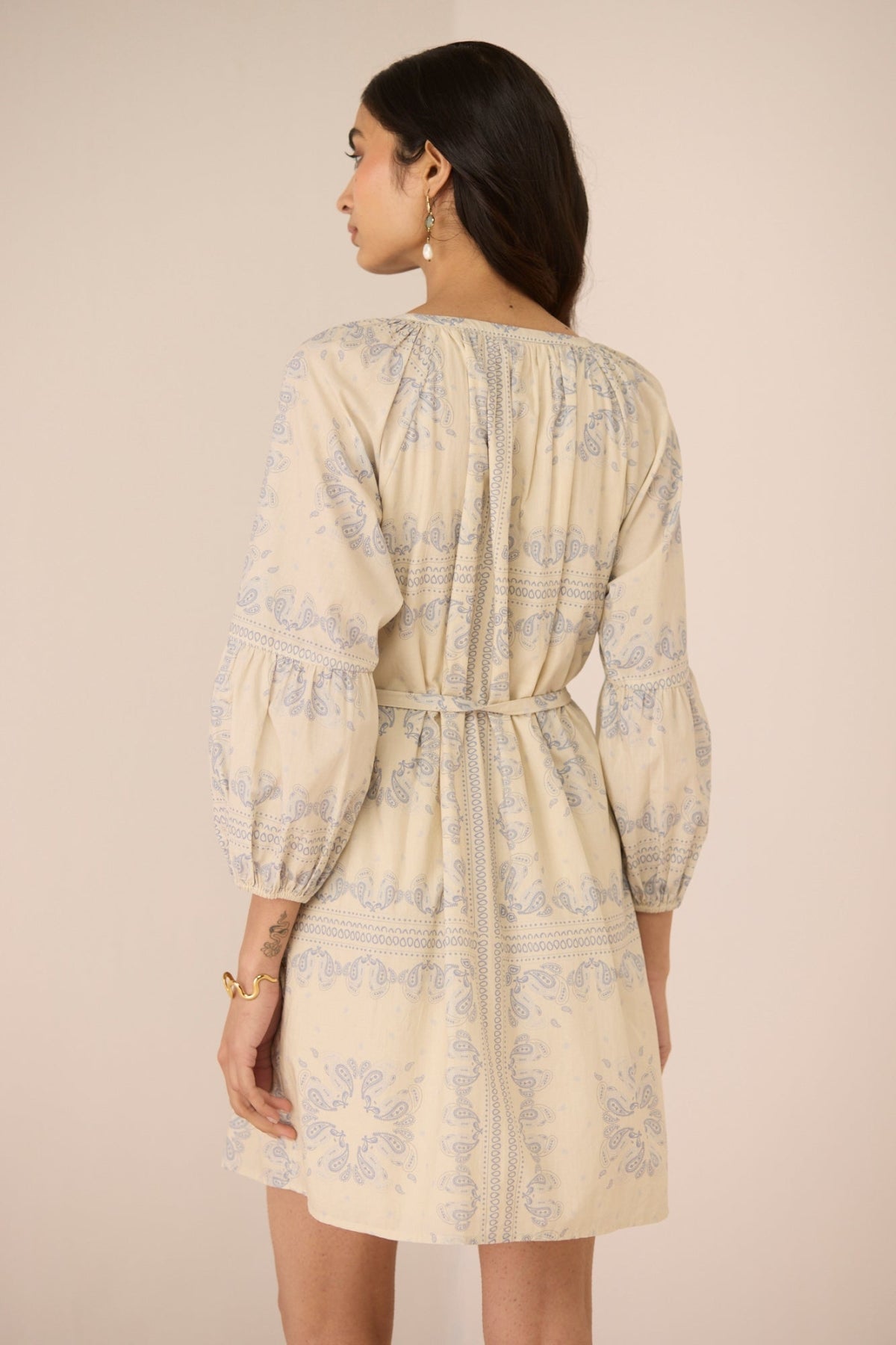 Woman wearing a beige floral dress against a beige background Calling June