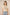 Woman wearing a beige top with floral embroidery and light blue jeans against a beige background Calling June
