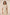 Woman wearing a beige dress with floral patterns against a plain background Calling June