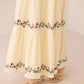 Beige skirt with floral embroidery on a plain background Calling June