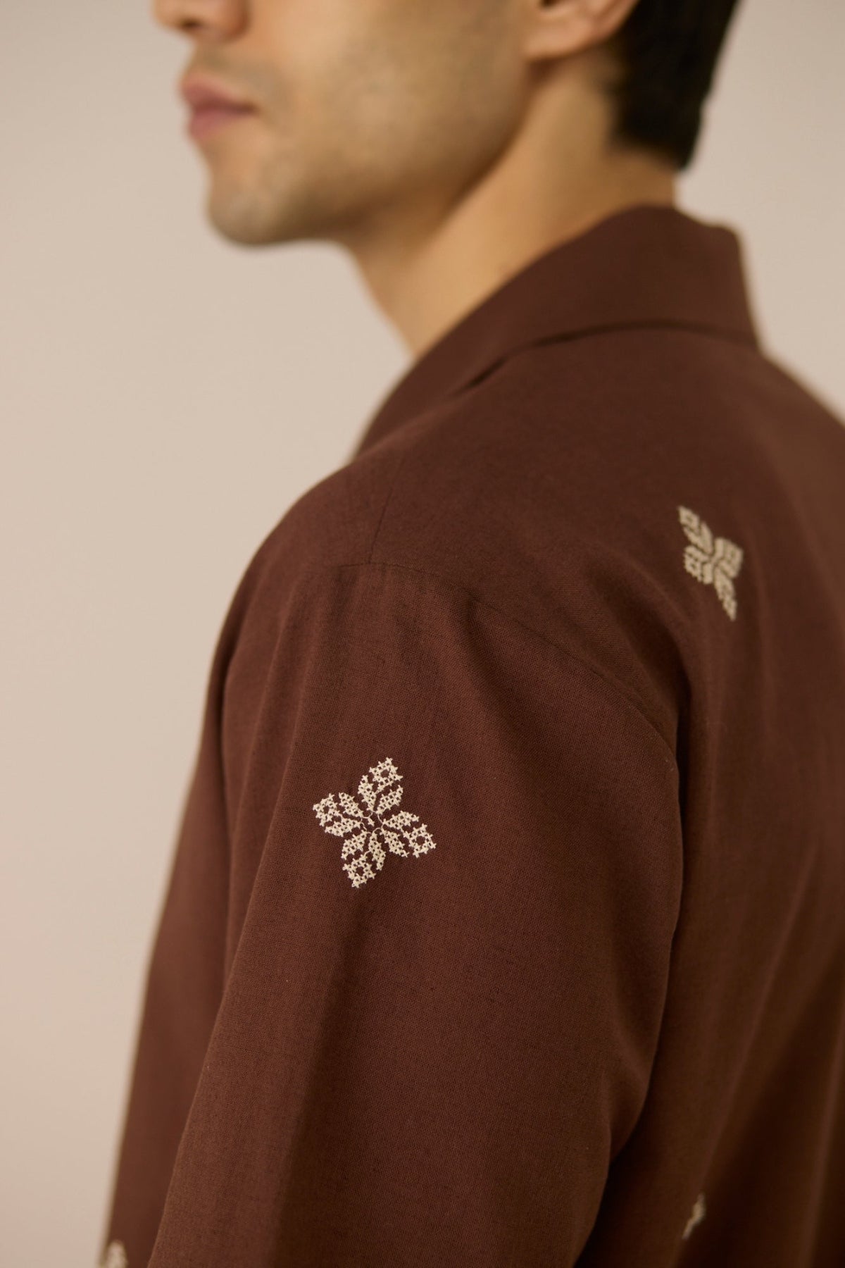 Brown shirt with floral embroidery on a plain background Calling June