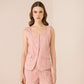 Woman wearing a pink striped outfit with a vest and shorts on a beige background Calling June