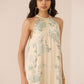 Woman wearing a floral halter neck dress against a plain background Calling June