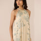 Woman wearing a floral dress against a plain background Calling June