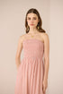 Woman wearing a pink strapless dress against a beige background Calling June