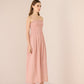 Woman wearing a pink strapless dress against a plain background Calling June