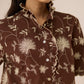 Woman wearing a brown floral patterned shirt against a neutral background Calling June