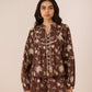 Woman wearing a brown floral patterned outfit on a beige background Calling June