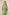 Woman wearing a green embroidered dress against a beige background Calling June