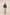 Woman wearing a black patterned blouse and light blue jeans on a beige background Calling June