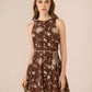 Woman wearing a brown floral dress against a beige background Calling June