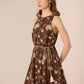 Woman wearing a brown floral dress against a beige background Calling June