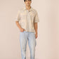 Man wearing a patterned shirt and light blue jeans against a plain background Calling June