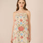 Woman wearing a floral dress against a beige background Calling June
