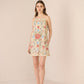 Woman wearing a floral dress against a plain background Calling June
