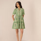 Woman wearing a green dress with white embroidery on a beige background Calling June