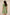 Woman wearing a green dress with embroidery details on a beige background Calling June