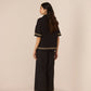Woman wearing a black outfit with lace details on a beige background Calling June