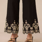 Black pants with white floral embroidery worn by a person on a beige background Calling June