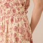 Close-up of a floral dress with pink flowers on a beige background Calling June
