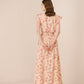 Woman wearing a floral dress against a plain background Calling June