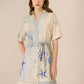 Woman wearing a patterned dress with a neutral background Calling June
