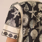 Man wearing a shirt with shell and starfish pattern on a beige background Calling June